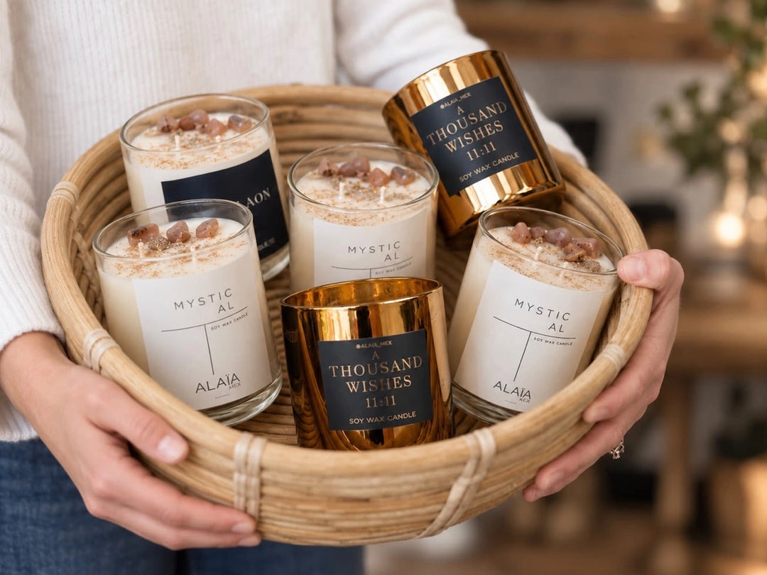 Manos sosteniendo una canasta con velas Alaïa en vaso blanco y dorado